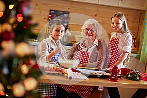 Smiling kids preparing Xmas cookies with grandmother