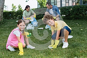 Smiling kids in rubber gloves holding