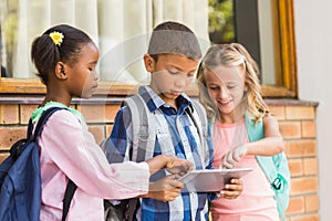 Smiling kids using a and digital tablet