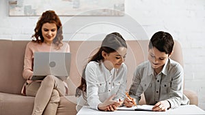 Smiling kids writing on notebook near