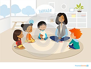 Smiling kindergarten teacher and children sitting in circle and meditating. Preschool activities and early childhood education con