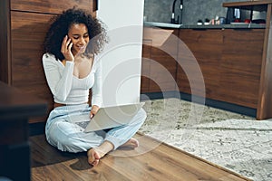 Smiling lady with a gadget pressed to her ear