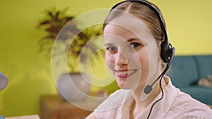 Smiling large in front of the camera beautiful operator agent at call centre in the office she wear the headset