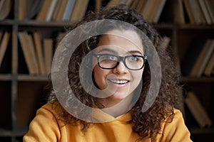 Smiling latin teen girl school student wear glasses looking at camera, headshot.