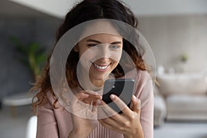 Smiling Latino woman use cellphone browsing internet