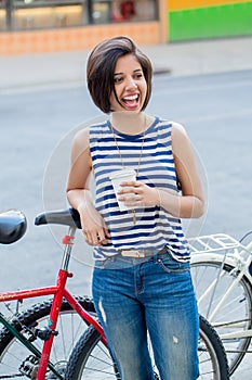 Smiling laughing young hipster latin colombian girl woman with short hair bob in blue ripped jeans
