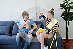 Smiling and lazy Young Caucasian couple love husband and wife funny and relaxing with Spray together on sofa for housework