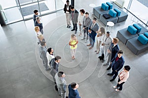 Smiling leader standing in front of his partners who applauding