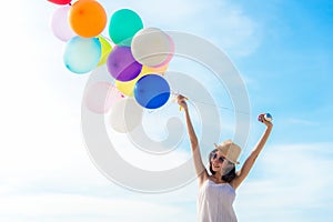 Smiling lifestyle asian woman chill hand holding balloon on the beach. Relax and Enjoy in summer holiday.