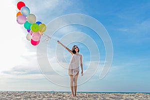 Smiling lifestyle asian woman hand holding balloon on the beach. Relax and Enjoy in summer holiday.