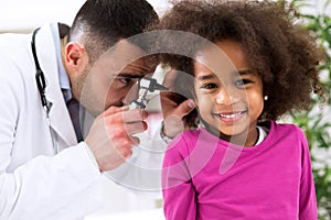 Smiling little african girl with ear specialist photo