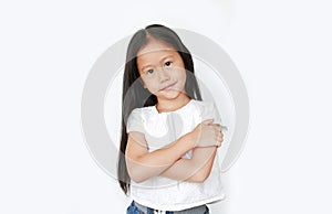 Smiling little Asian child girl expression cross one`s arm and looking camera isolated on white background. Confident and cheerfu