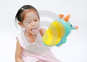 Smiling little Asian child girl hand wear and playing Rhinoceros puppets on white background. Educations concept photo