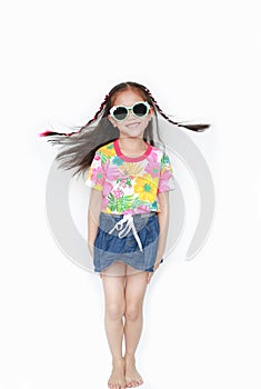 Smiling little Asian child girl wearing a floral pattern summer dress and sunglasses isolated on white background. Summer and