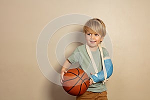 Smiling little blond boy with basketball ball