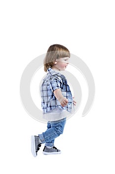 Smiling little boy 2 years old runs. Child wearing a blue checkered shirt and a white T-shirt. Activity, energy and childlike