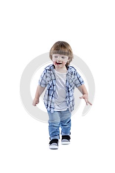 Smiling little boy 2 years old runs. Child wearing a blue checkered shirt and a white T-shirt. Activity, energy and childlike