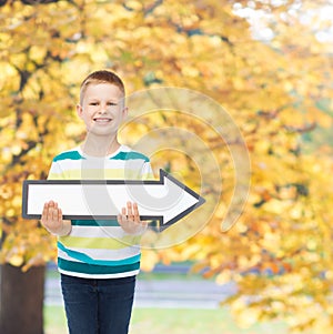 Smiling little boy with blank arrow pointing right