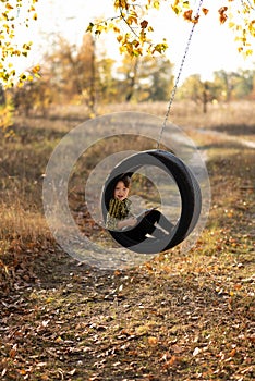 Smiling little boy with book in wheel swing outdoors