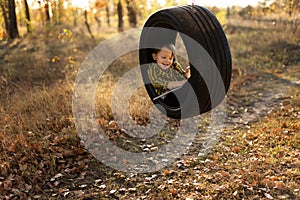 Smiling little boy with book in wheel swing outdoors