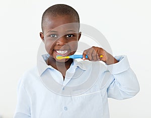 Smiling little boy brushing his teeth