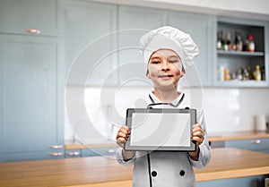 smiling little boy in chef& x27;s toque with tablet pc