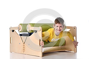 Smiling little boy demonstrating usage of exercise set for persons with locomotor disorder, isolated on white, copy space