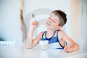 Smiling little boy eating delicious yogurt
