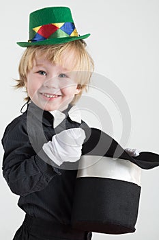 Smiling little boy in a green hat holding a black