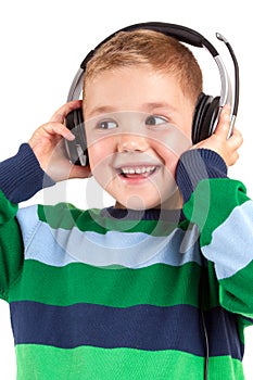 Smiling little boy listening to music in headphon