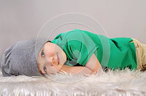 Smiling little boy is lying on fur