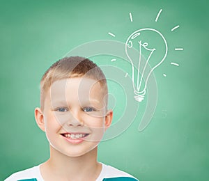 Smiling little boy over green board background