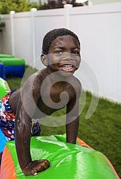 Smiling little boy playing outdoors on an inflatable bounce house