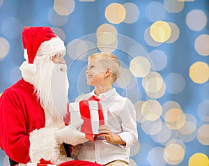 Smiling little boy with santa claus and gifts