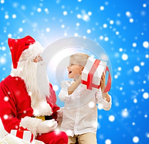 Smiling little boy with santa claus and gifts