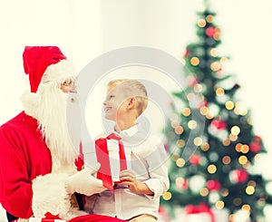 Smiling little boy with santa claus and gifts