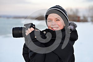 Smiling little caucasian boy taking photos outdoor