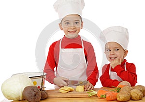 Smiling little chief-cookers on the desk