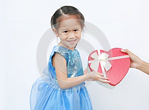 Smiling little child girl receiving red heart gift box isolated on white background. Concept Valentine`s Day