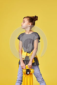 smiling little child girl with yellow skateboard