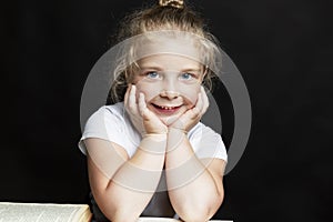 Smiling little girl with books. Knowledge and education. Back to school. Black background