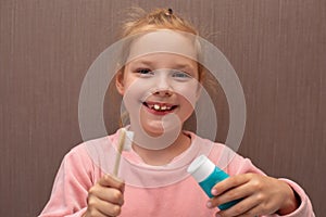 Smiling little girl brushing her teeth