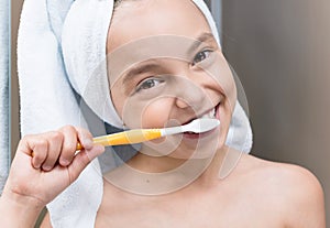 Smiling little girl brushing teeth