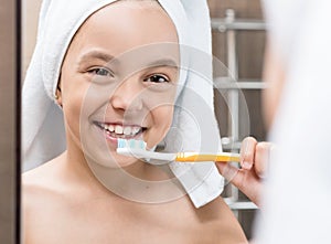 Smiling little girl brushing teeth