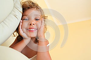 Smiling little girl in cosy room, foreshortening