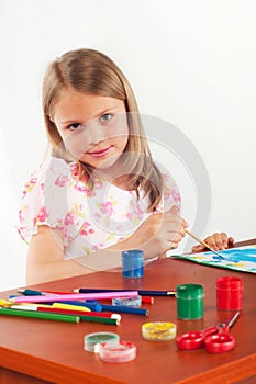 Smiling little girl drawing picture, paints, hobby