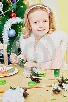 Smiling little girl dressed in furry mantle sits photo
