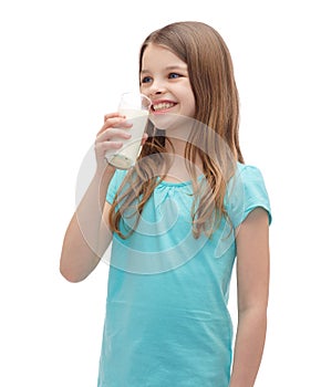 Smiling little girl drinking milk out of glass