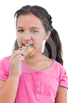 Smiling little girl eating a cookie