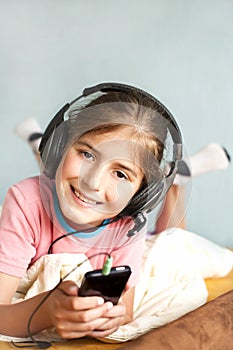 Smiling little girl enjoys music